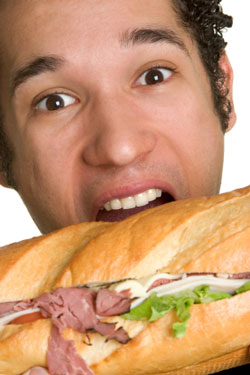 man eating a huge sandwich