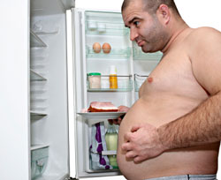 overweight man looking in refrigerator 